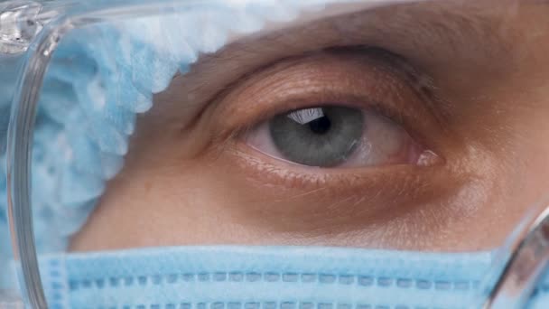 Polotvář Doktorky, Oči v bezpečnostních brýlích. Zdravotní zaměstnanec hledící do kamery. Portrétní lékařka s ochranou a brýlemi v nemocnici nebo na klinice. Novel Coronavirus 2019-nCoV — Stock video