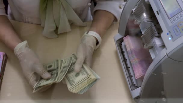 Banker Hands Counting Dollars, Machine Counting Ukrainian Hryvnias Bills (en inglés). Manos del Empleado en Guantes Médicos Recupera Dólares Americanos e Hryvnias. en Real Cambio de Moneda Ucrania Oficina — Vídeos de Stock