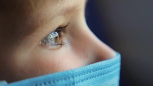 Close Up Eyes Boy Watching the Changing View Outside the Window. Light from the Window Flickers on the Kid Face in a Medical Mask During Goes, Ride by Train, Car, Bus, Subway. Coronavirus, COVID-19 — Stock Video