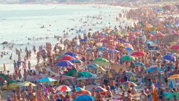 Strand fuld af mennesker og Sun Paraplyer i Hot Summer Day. Kæmpe skare af turister på stranden i højsæsonen. Kystlinien er fyldt med badende. Rejser til Europa, Ukraine, Odessa City. Tidsforløb – Stock-video