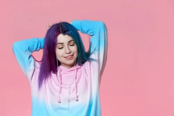 Mutlu kız pembe arka planda müzik dinliyor.