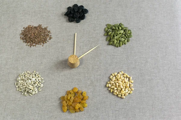 Kuruyemiş ve tohumlar bir arka plan üzerinde bir saat