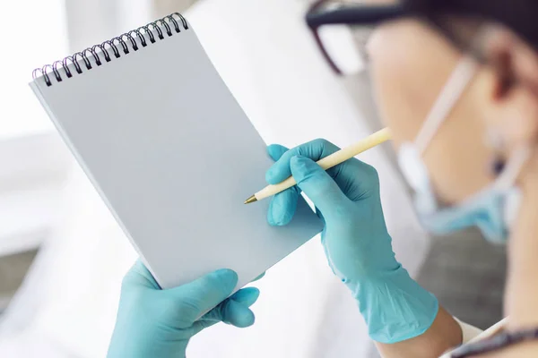 Doktor bir defter anamnezde yazıyor. Birinci şahıs bakış