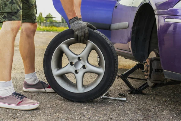 Arabada delinmiş lastik insanı değiştirir