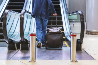 adamla bir bavul ve çanta gider yürüyen