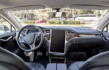 Güneşli bir günde modern bir elektrikli araba iç. şehir arka planda bulanık