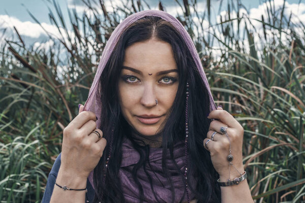 portrait of a beautiful shaman woman on blurry clods background