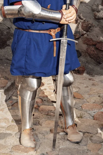 中世纪的骑士手里拿着剑 站在石墙前。 下半身 — 图库照片
