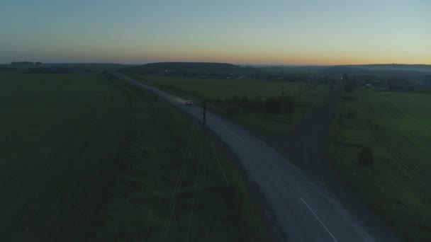 El coche cabalga al amanecer en la carretera — Vídeo de stock
