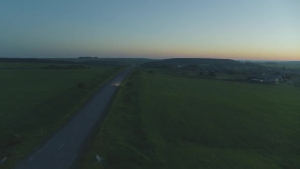 El coche cabalga al amanecer en la carretera — Vídeos de Stock