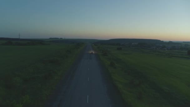 El coche cabalga al amanecer en la carretera — Vídeos de Stock