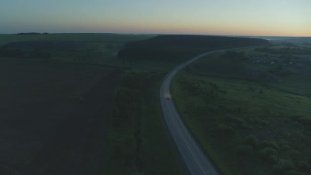 El coche cabalga al amanecer en la carretera — Vídeo de stock