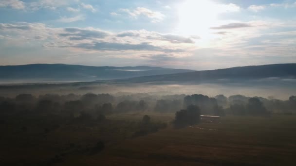 Mist in de vroege ochtend aan de voet van de bergen — Stockvideo