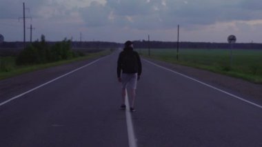 Gezgin boş bir yolda sabah erken gider.