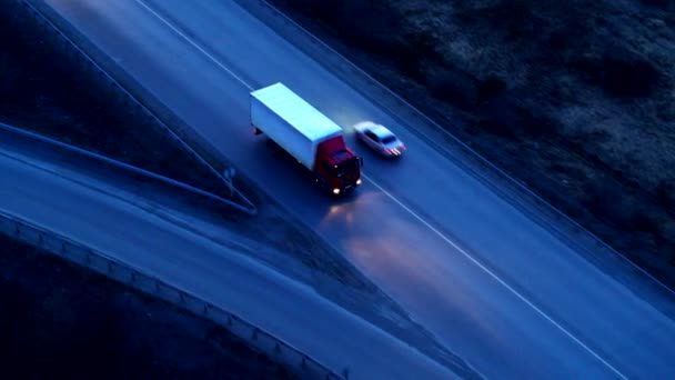 Вид з повітря на вантажівку, яка їде на величезній розв'язці під час заходу сонця . — стокове відео