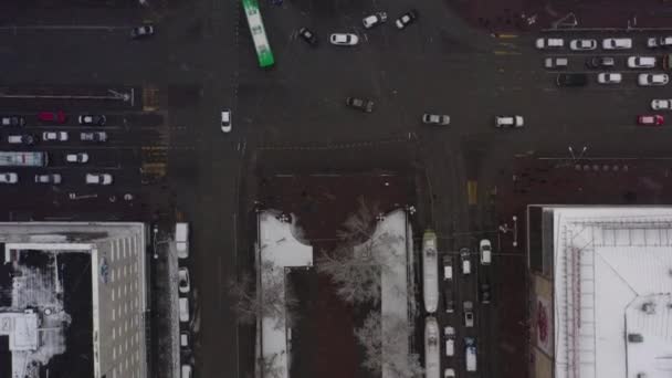 Luchtfoto van een druk kruising met dicht verkeer tijdens zware sneeuwval. — Stockvideo