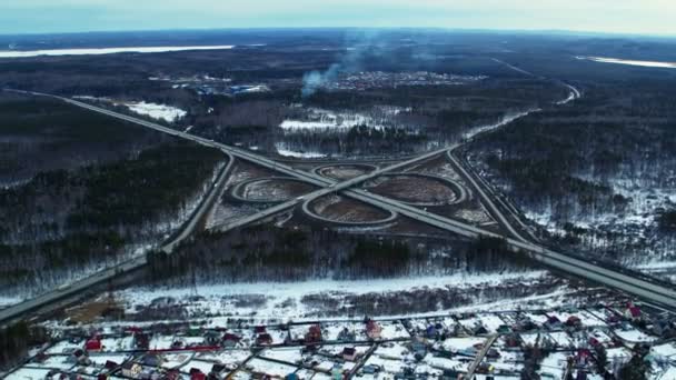 Огромный дорожный узел, полный автомобилей и грузовиков в сельской местности в зимний период, вид с воздуха . — стоковое видео