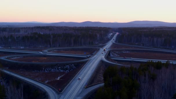 Enorme cruce de carreteras lleno de coches y camiones en el campo en invierno, vista aérea . — Vídeo de stock