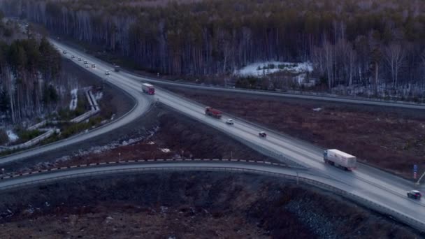 Вид з повітря на вантажівку, яка їде на величезній розв'язці під час заходу сонця . — стокове відео