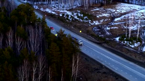 Flygbild av den röda bilen som rider på en enorm korsning vid solnedgången. — Stockvideo