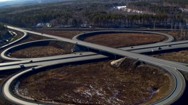 Huge road junction full of cars and trucks in countryside in winter, aerial view. — Stock Video