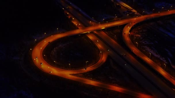 Luftaufnahme einer großen beleuchteten Straßenkreuzung in der Nacht voller Autos und Lastwagen. — Stockvideo