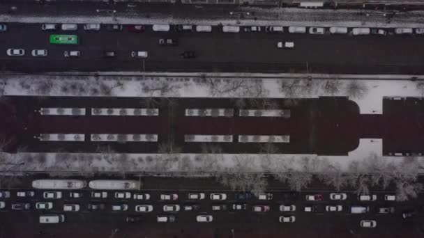 Aerial view of a busy intersection with dense traffic during heavy snowfall. — Stock Video