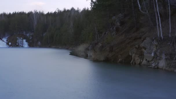 Veduta aerea di un piccolo lago con un sottile strato di ghiaccio nella foresta . — Video Stock