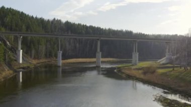 Bir yol köprüsünün altında suyun üzerinde uçarken