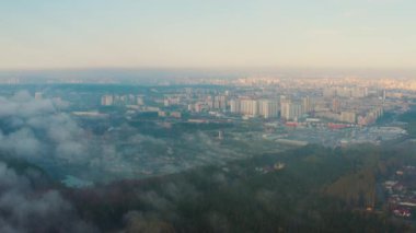 Ormandan bulutlara doğru büyük şehrin havadan görünüşü.