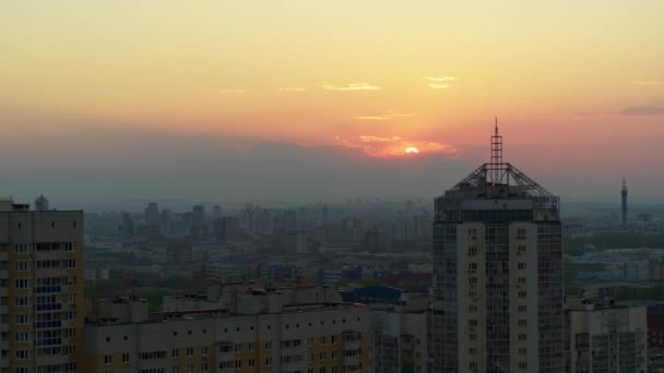 Şehrin üzerindeki parlak turuncu gün batımının havadan görüntüsü. — Stok video