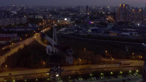 Une vue aérienne de la grue de construction et de la construction du bâtiment au crépuscule. — Video