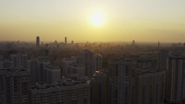 Şehrin üzerindeki parlak turuncu gün batımının havadan görüntüsü. — Stok video