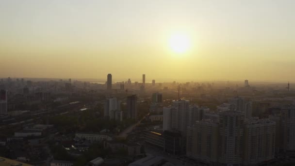 Şehrin üzerindeki parlak turuncu gün batımının havadan görüntüsü. — Stok video