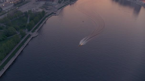 Vzdušný pohled na loď, která plave na řece v centru města při západu slunce — Stock video
