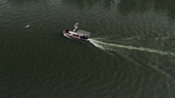 Вид с воздуха на лодку, плывущую вдоль реки в центре города — стоковое видео