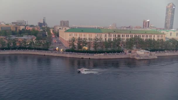 Veduta aerea di una barca che galleggia su un fiume nel centro della città al tramonto — Video Stock