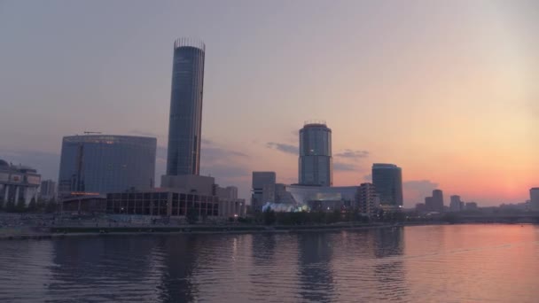 Blick aus der Luft bei einem wunderschönen rosafarbenen Sonnenuntergang über dem Fluss im Stadtzentrum — Stockvideo