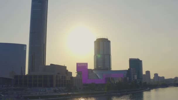 Blick aus der Luft bei einem wunderschönen rosafarbenen Sonnenuntergang über dem Fluss im Stadtzentrum — Stockvideo