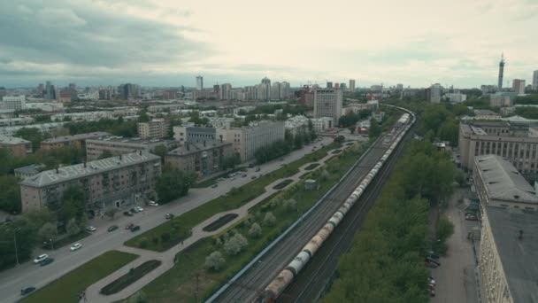 Demiryolunun yanındaki trafiğin olduğu caddenin havadan görüntüsü. — Stok video