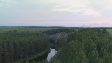 Nehrin havadan görünüşü ve kıyılarında bir kaya ve orman.