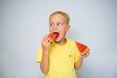 Neşeli beyaz 5 yaşındaki sarı t-shirt burunlu ve kırmızı karpuz, yaz kavramı bir parça yemek.