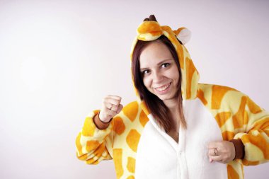 kız bir parlak çocuk pijama bir zürafa şeklinde. duygusal bir öğrenci portresi. Çocuk animatör sunumunu kostüm. Kedinin pençeleri şeklinde terlik.         