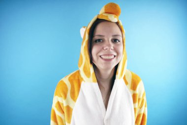 kız bir parlak çocuk pijama bir zürafa şeklinde. duygusal bir öğrenci portresi. Çocuk animatör sunumunu kostüm. Kedinin pençeleri şeklinde terlik.         