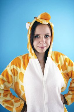 kız bir parlak çocuk pijama bir zürafa şeklinde. duygusal bir öğrenci portresi. Çocuk animatör sunumunu kostüm. Kedinin pençeleri şeklinde terlik.         