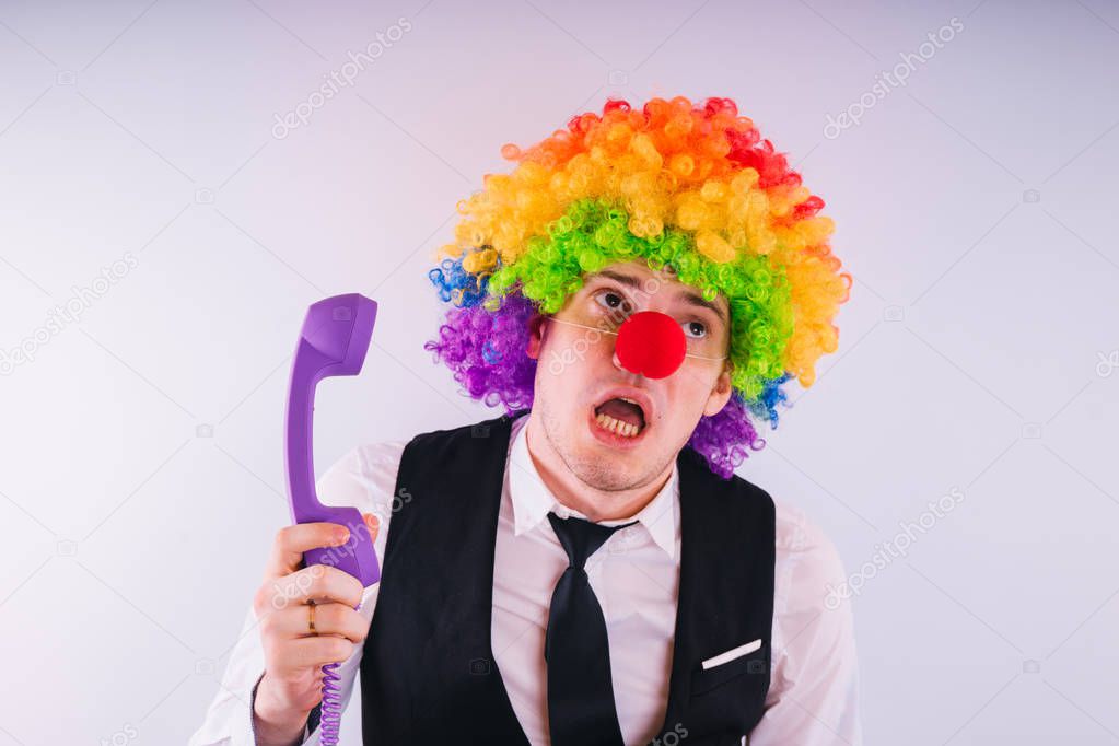 Office worker in clown wig, clown concept at work. Businessman with clown wig isolated on white