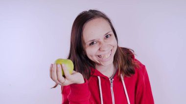 El Beyaz arka plan üzerinde izole yeşil meyve tutan, yakın çekim. Kız yüz taze elma tutar. Bahçe ve sonbahar kavramı. Kadınlar sunar homegrown hasat