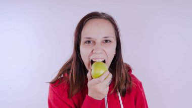 El Beyaz arka plan üzerinde izole yeşil meyve tutan, yakın çekim. Kız yüz taze elma tutar. Bahçe ve sonbahar kavramı. Kadınlar sunar homegrown hasat