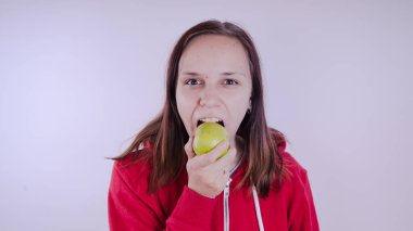El Beyaz arka plan üzerinde izole yeşil meyve tutan, yakın çekim. Kız yüz taze elma tutar. Bahçe ve sonbahar kavramı. Kadınlar sunar homegrown hasat
