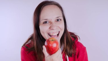 El Beyaz arka plan üzerinde izole kırmızı meyve tutan, yakın çekim. Kız yüz taze elma tutar. Bahçe ve sonbahar kavramı. Kadınlar sunar homegrown hasat